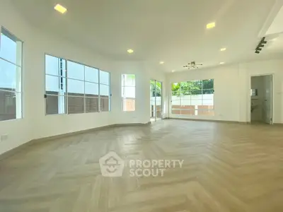 Spacious and bright living room with large windows and modern lighting