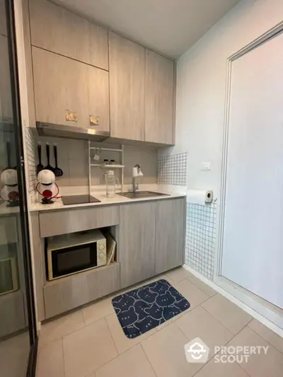 Modern compact kitchen with microwave and sleek cabinetry