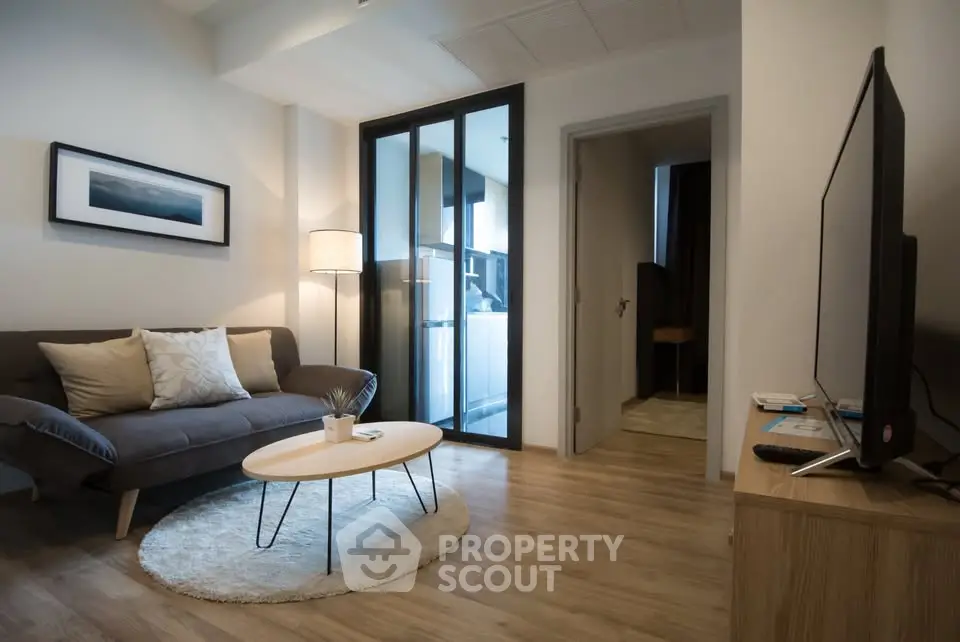 Modern living room with cozy sofa, stylish decor, and open kitchen layout in a contemporary apartment.