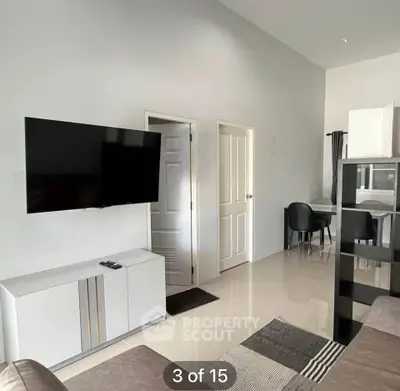 Modern living room with wall-mounted TV and sleek furniture in a stylish apartment.