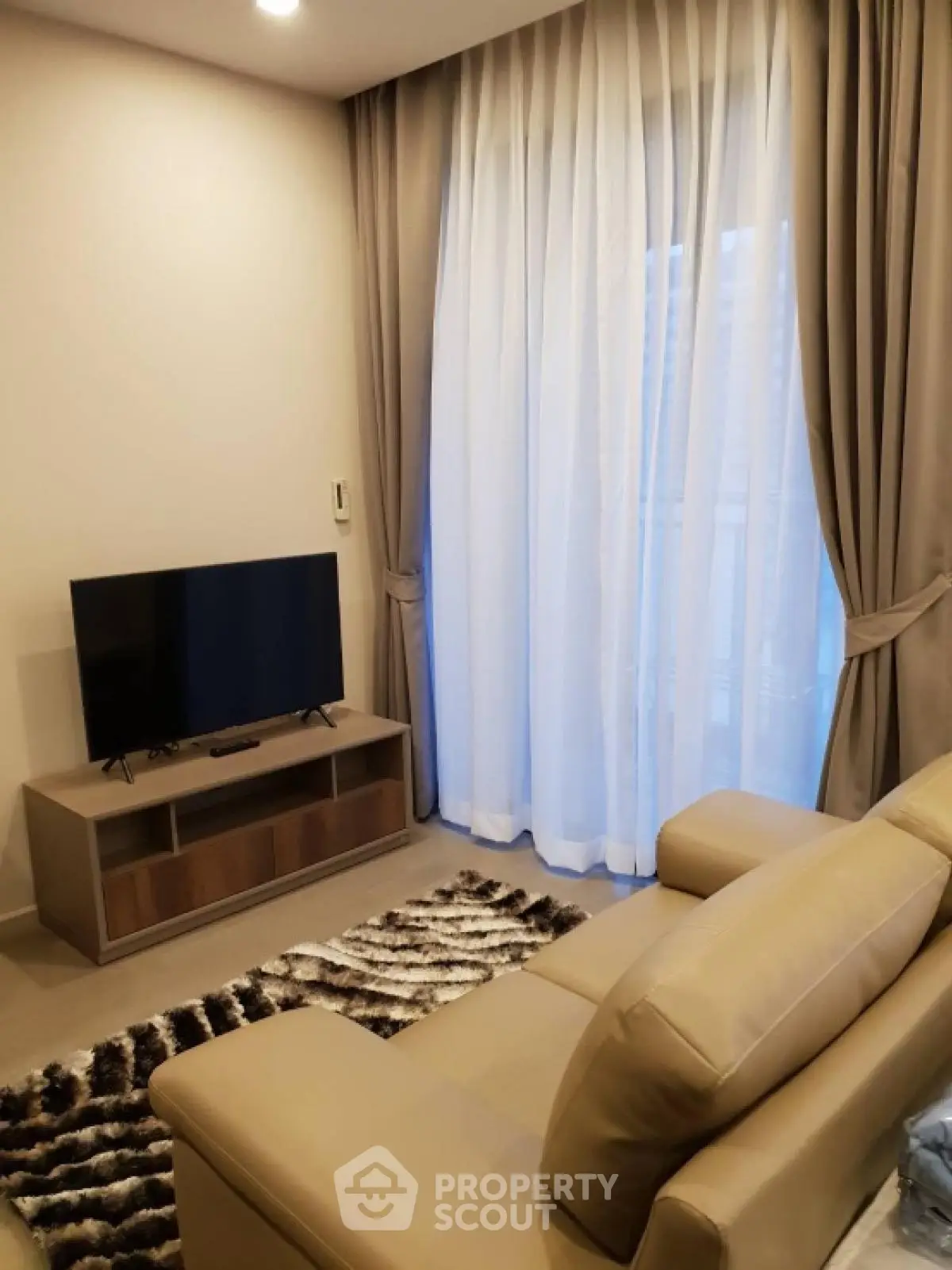 Cozy living room with modern decor and large window curtains