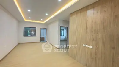 Spacious modern living room with wooden accents and recessed lighting