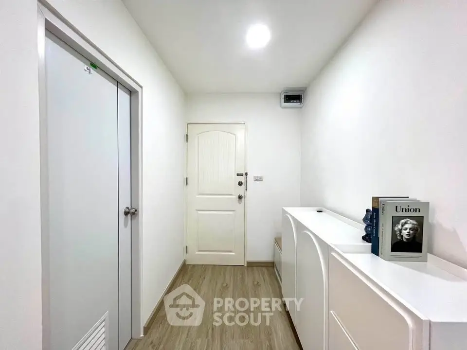 Modern minimalist hallway with sleek white cabinetry and wood flooring