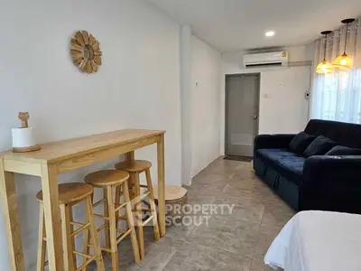 Cozy living room with modern decor and natural light, featuring a stylish wooden bar table and comfortable seating.