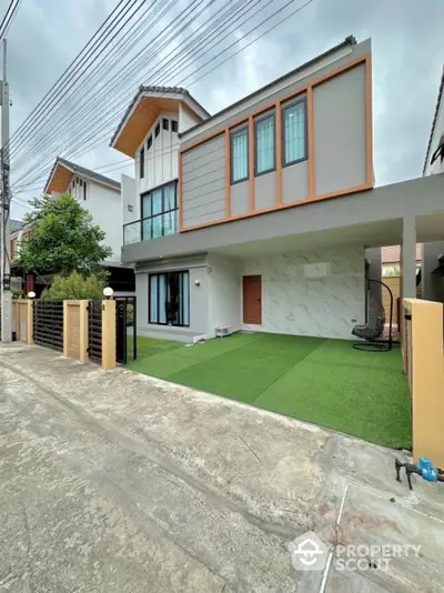 Modern two-story house with sleek design and artificial grass lawn