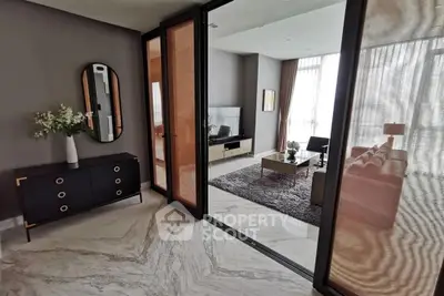 Elegant living room with modern decor and marble flooring, featuring a cozy seating area and stylish furniture.