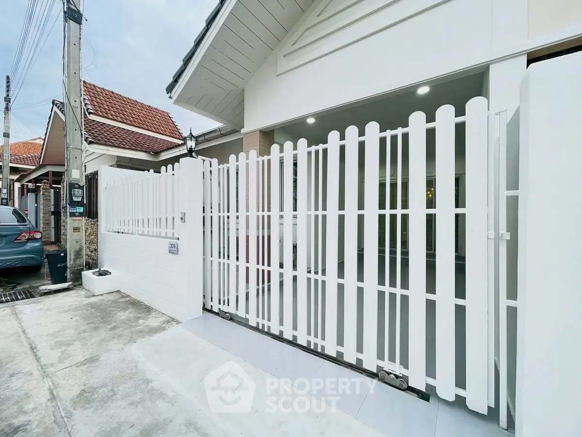 Charming residential entrance with white picket fence and modern design.