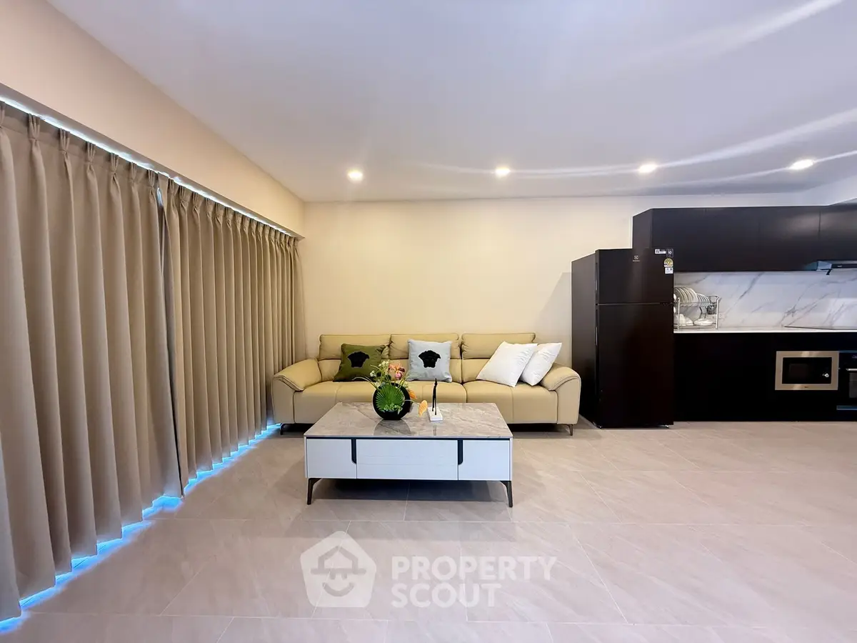 Spacious modern living room with sleek kitchen and cozy seating area