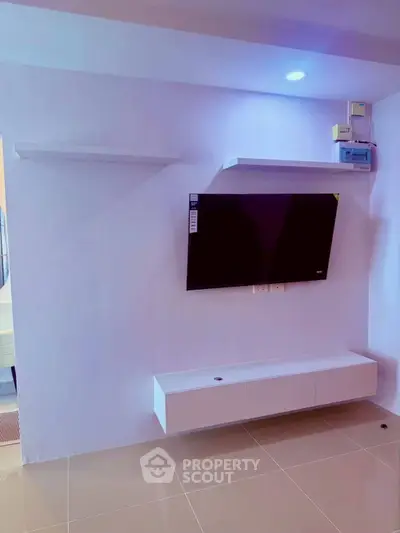 Modern living room with wall-mounted TV and sleek storage unit