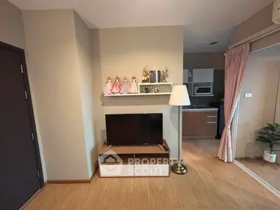 Modern living room with TV stand, decorative shelf, and view into a stylish kitchen area.