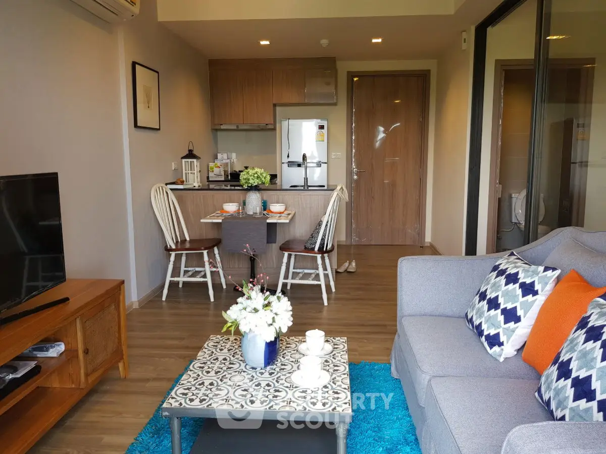 Modern living room with stylish decor and open kitchen layout, featuring cozy seating and elegant dining area.