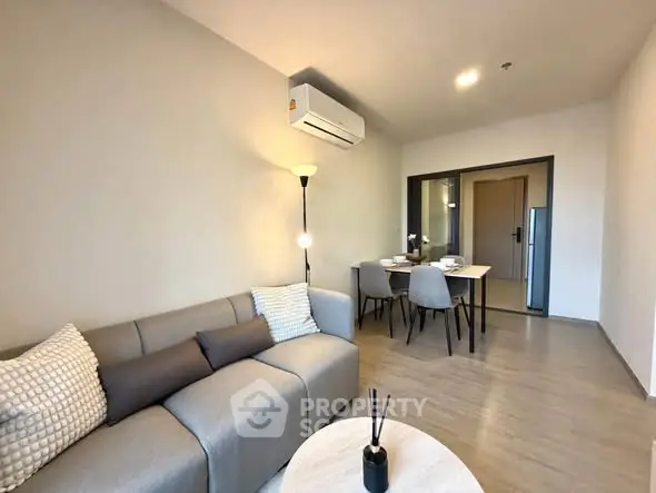 Modern living room with cozy sofa and dining area in open layout apartment.