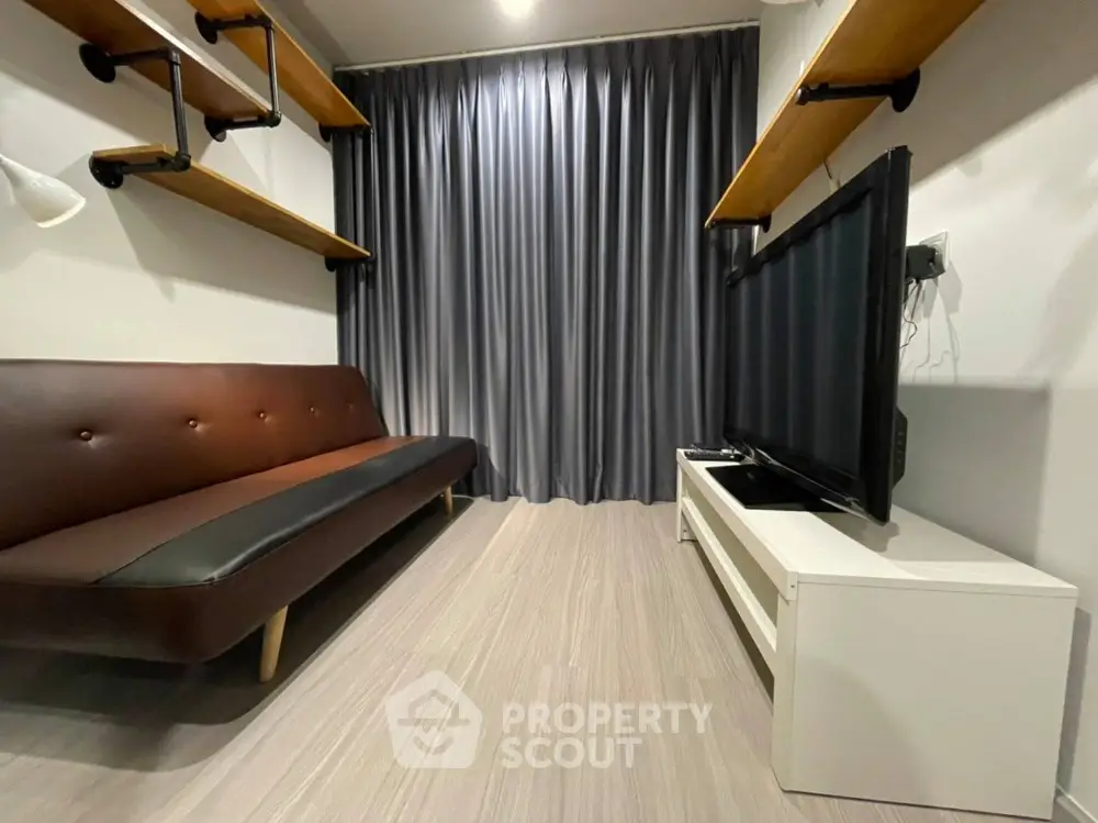 Modern living room with sleek sofa and large TV, perfect for relaxation and entertainment.