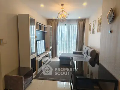 Modern living room with stylish decor and large window offering city views.