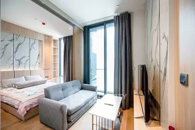 Modern studio apartment with stylish decor and large windows offering ample natural light.