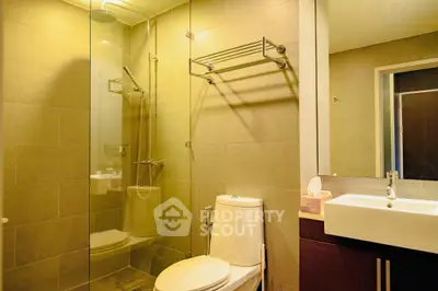 Modern bathroom with glass shower and sleek fixtures in elegant real estate property.