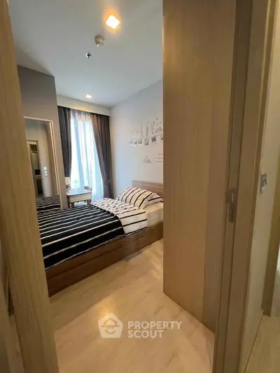 Cozy bedroom with modern decor and natural light in a stylish apartment.