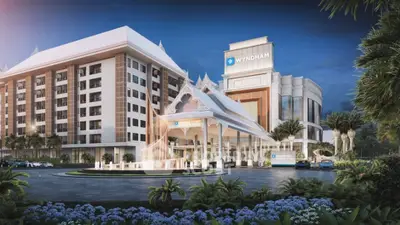 Majestic hotel facade with grand entrance and lush landscaping, showcasing a modern design with classic touches, ideal for upscale hospitality real estate.