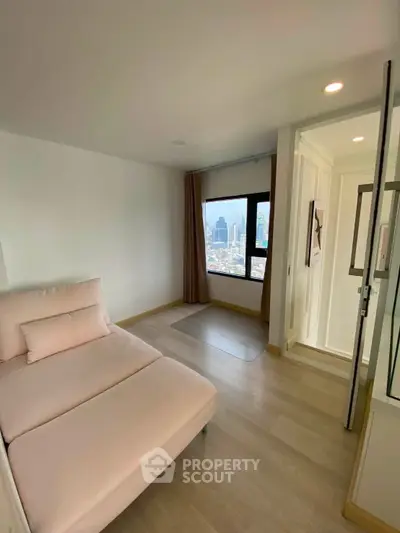 Modern apartment with cozy seating and city view, featuring elegant decor and natural light.