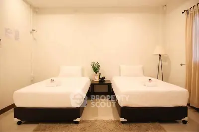 Spacious twin bedroom with modern decor and cozy ambiance, perfect for relaxation.