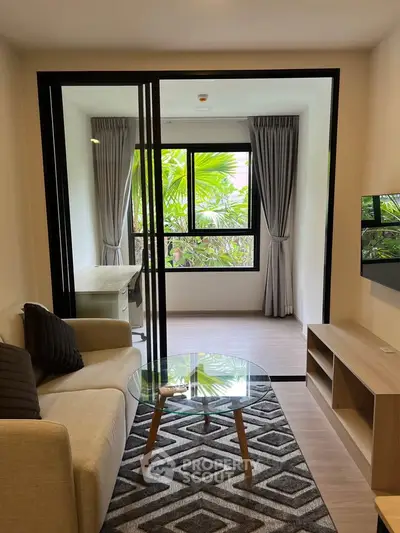 Modern living room with glass partition and garden view, featuring cozy sofa and stylish decor.
