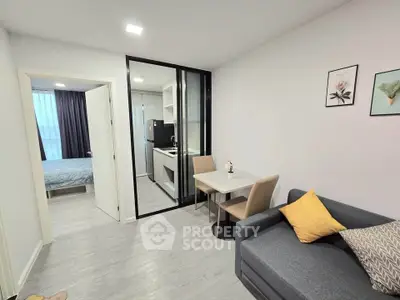 Modern apartment interior with open layout, featuring cozy living room and compact kitchen.