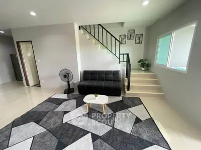 Modern living room with stylish geometric rug and sleek black sofa
