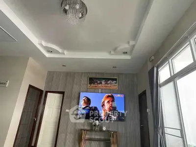 Modern living room with stylish ceiling design and wall-mounted TV