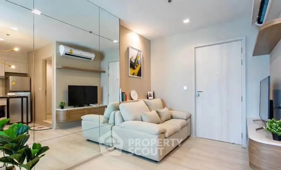 Modern living room with mirrored wall and cozy beige sofa in stylish apartment.