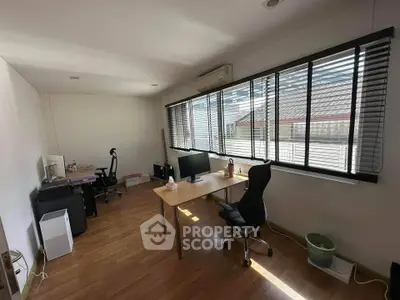 Spacious study room with large windows and modern furniture, perfect for productivity.