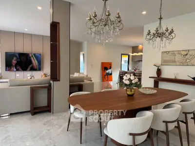 Luxurious open-plan living and dining area with elegant chandeliers and modern decor.