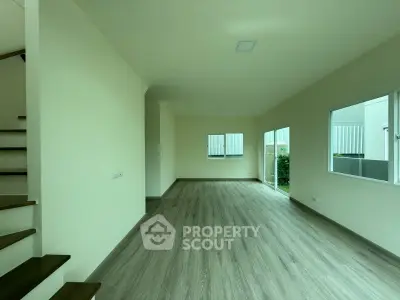 Spacious modern living room with wooden flooring and large windows