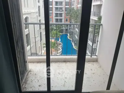 Charming balcony view overlooking a luxurious pool in a modern apartment complex.