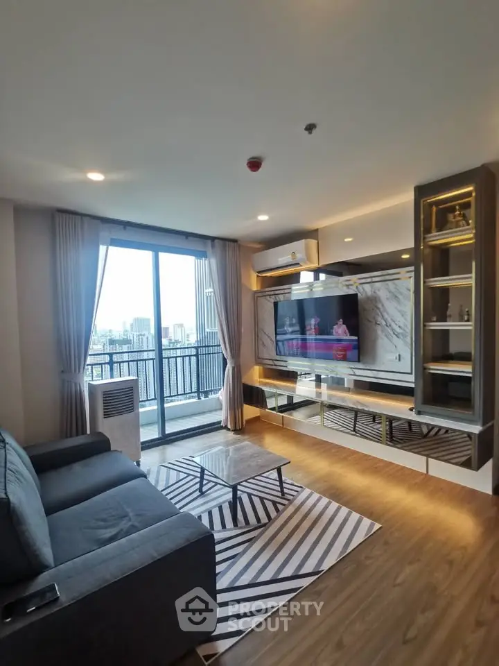 Modern living room with city view, stylish decor, and large windows in a high-rise apartment.