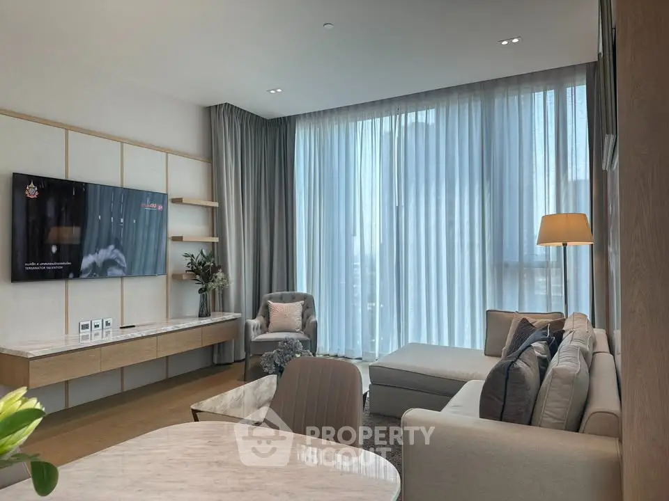 Luxurious modern living room with elegant decor and large windows offering natural light.