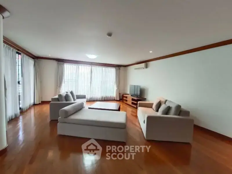 Spacious living room with elegant hardwood floors and modern furniture