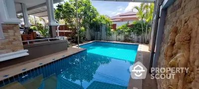 Luxurious private pool area with tropical garden and elegant stone wall decor