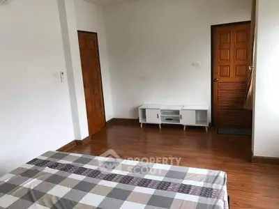 Spacious bedroom with wooden flooring and minimalist decor