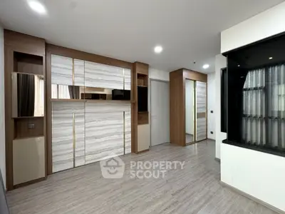 Modern interior with sleek wooden cabinetry and large windows in a stylish apartment.