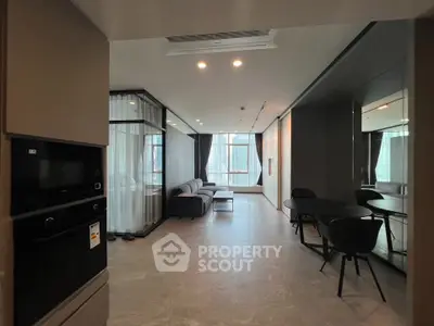 Modern open-plan living room with sleek furniture and large windows offering city views.