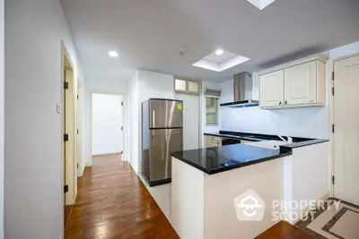 Spacious kitchen with modern appliances and open layout, featuring a large refrigerator, sleek countertops, and ample cabinet space, perfect for culinary enthusiasts.