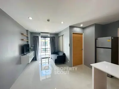 Modern living room with sleek design, featuring a cozy sofa, wall-mounted TV, and natural light from large windows.
