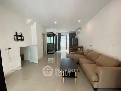 Spacious modern living room with beige sofa and sleek tile flooring