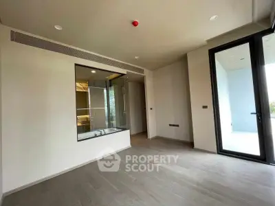 Spacious modern bedroom with large window and sleek flooring