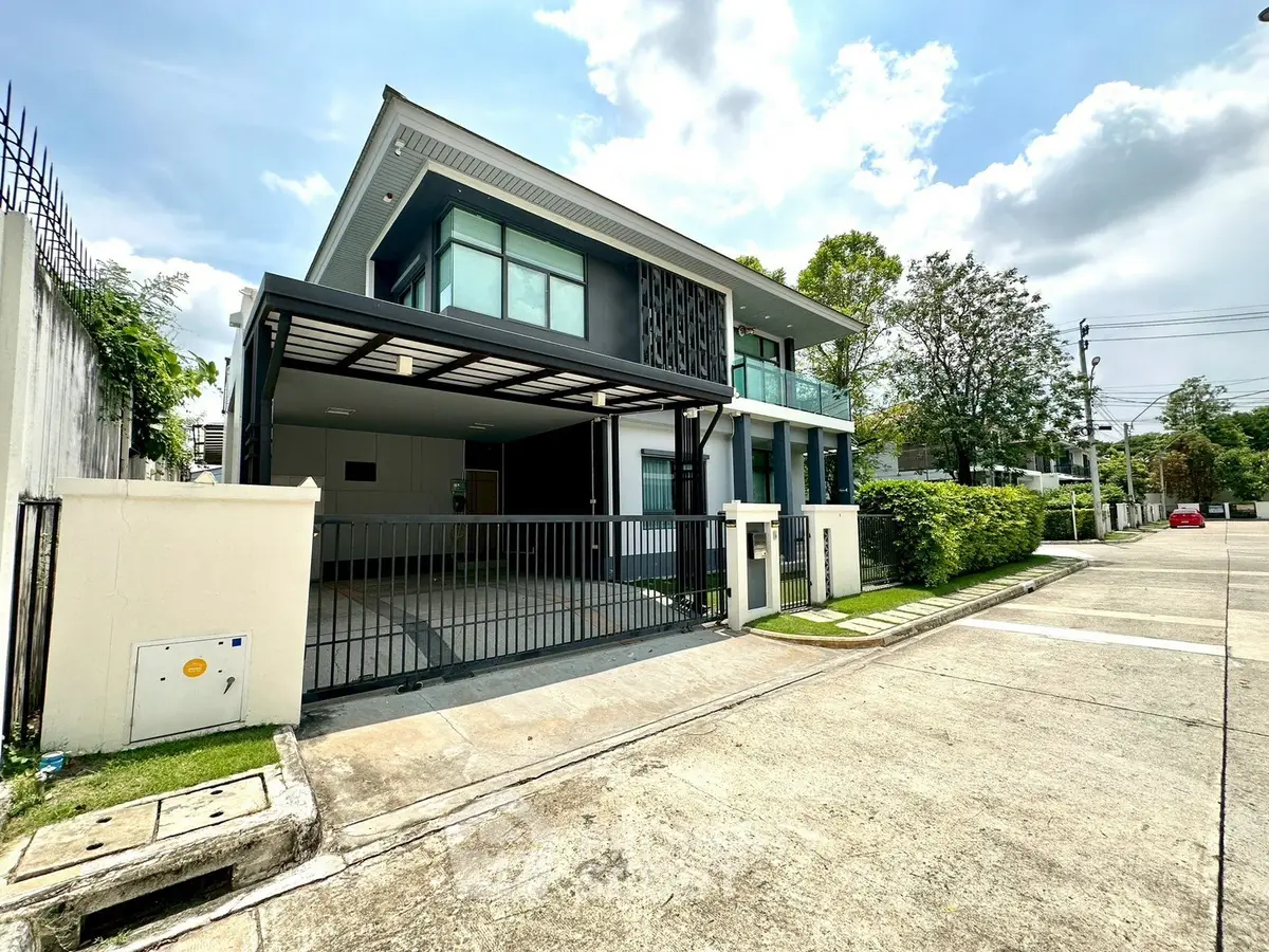 Modern two-story house with sleek design and spacious driveway in a serene neighborhood.