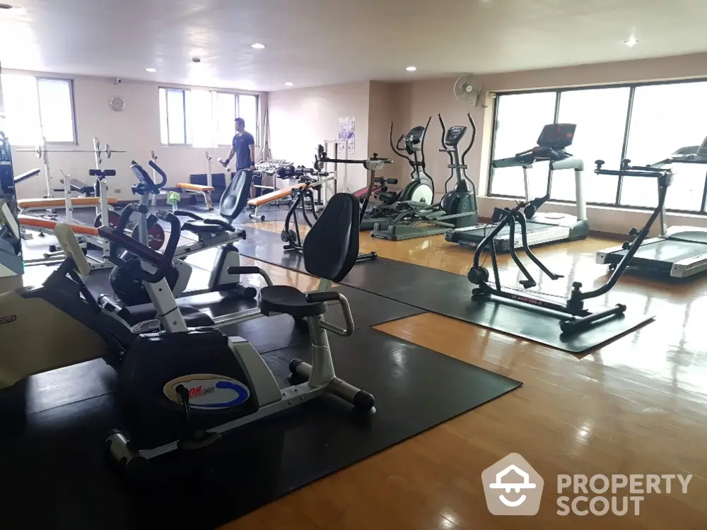 Spacious gym with modern exercise equipment and natural light