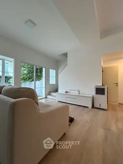 Spacious modern living room with natural light and minimalist design, perfect for relaxation and entertainment.