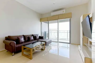 Modern living room with sleek furniture and large windows offering natural light.