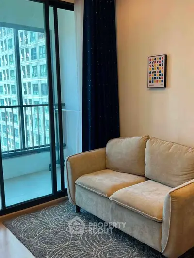 Cozy living room with a plush sofa and balcony view in a modern apartment.