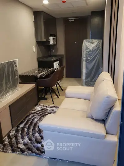 Modern compact living room with cozy sofa and stylish dining area in urban apartment.